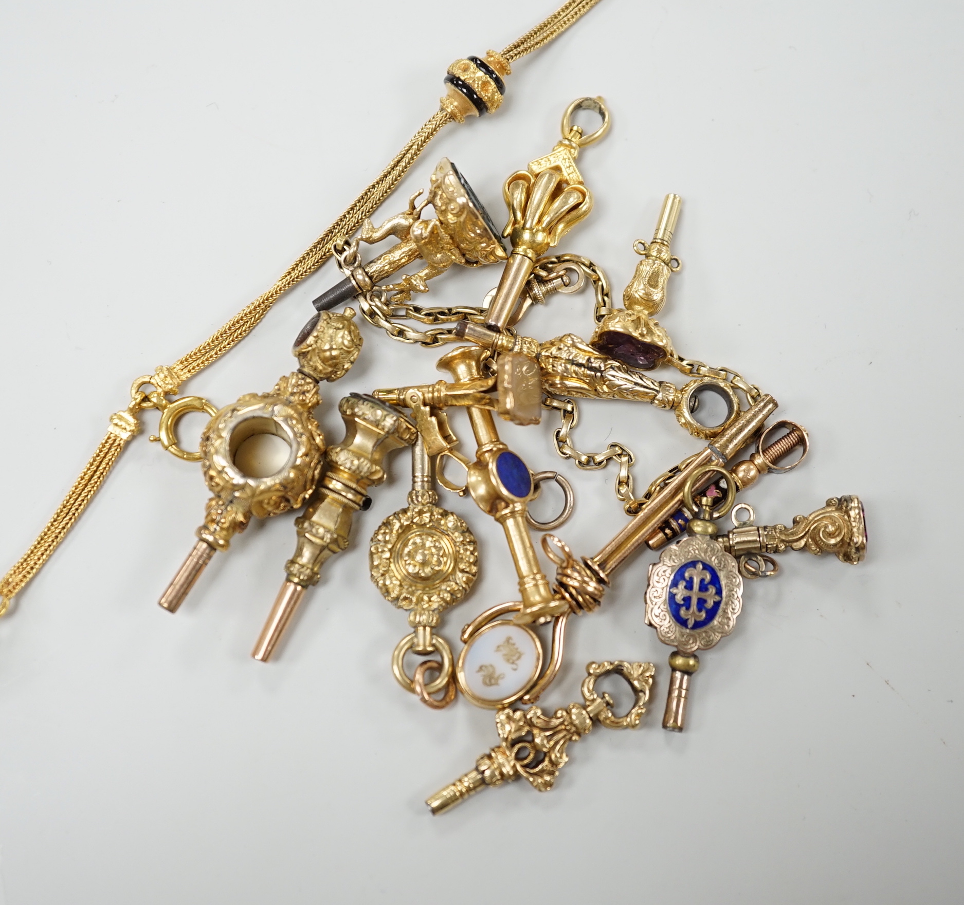 A small collection of fifteen assorted mainly 19th century yellow metal or gold plated watch keys including, one rose cut diamond set, one enamelled locket, six gem stone set, one enamelled, one surmounted with deer and